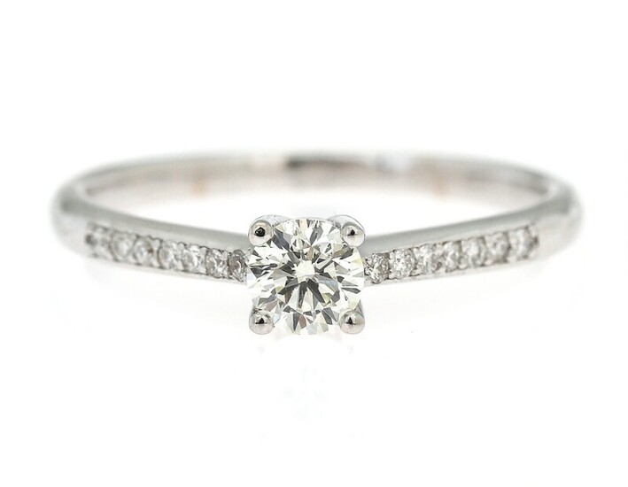 NOT SOLD. A diamond ring set with a brilliant-cut diamond flanked by numerous diamonds, mounted...
