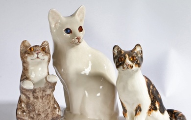 A group of three 'Winstanley' pottery seated Cats, stamped t...