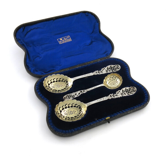 A pair of Edwardian parcel-gilt fruit serving spoons and a sifting spoon