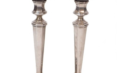 A pair of silver candlesticks, Sheffield, 1926 and 1928, James Dixon & Sons, the tapering, faceted stems to stepped square bases and fixed octagonal capitals, 26cm high, filled (pr)