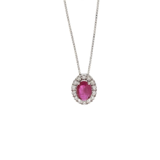 A pendant set with an oval-cut ruby weighing app. 0.64 ct. encircled by numerous diamonds, mounted in 18k white gold. Accompanied by chain of 18k white gold.