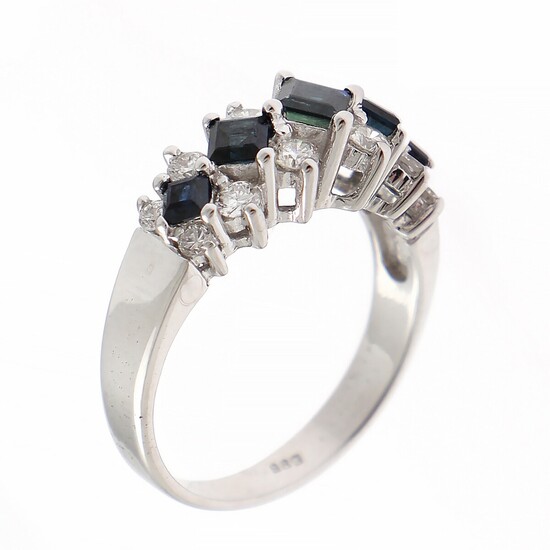 A sapphire and diamond ring set with five square-cut sapphires flanked by numerous brilliant-cut diamonds, mounted in 14k white gold. Size 57.