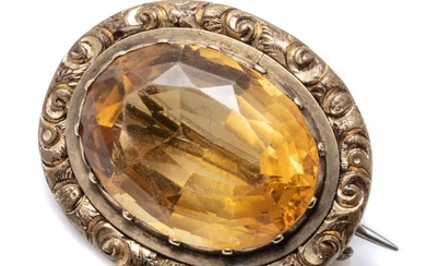 AN ANTIQUE GOLD CASED CITRINE BROOCH; oval cut citrine of approx. 11.65ct to engraved surround, size 25 x 20mm.