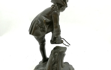 ANTIQUE CONTINENTAL BRONZE FIGURE OF A YOUNG MALE TYING ON AN ICE SKATE.
