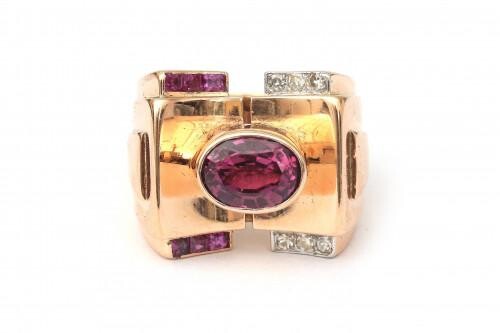 An 18 karat rose gold tourmaline, ruby and diamond cocktail ring, ca. 1950. Featuring an oval cut rubelite tourmaline of ca. 2.67 ct., six small old European cut diamonds and six carre cut rubies. Incl. leather ring box of Leysen Frères, Bruxelles...