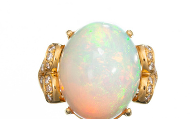 Bague en or jaune sertie au centre d'une opale cabochon pesant environ 15 cts entre 2 cœurs pavés de 28 diamants