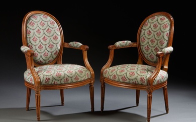 Deux fauteuils cabriolet à dossier médaillon faisant pendant, en bois naturel mouluré et sculpté de...