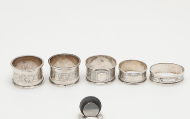 FIVE SILVER NAPKIN RINGS AND A SILVER PLACE CARD HOLDER.