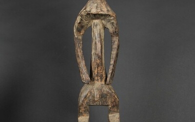 Figure Iagalagana en bois avec ancienne patine d’usage brune et petites érosions du temps localisées,...