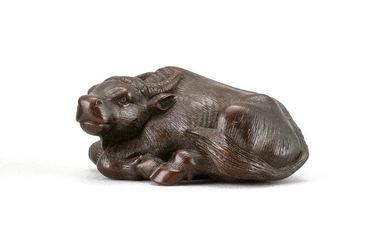 JAPANESE WOOD NETSUKE By Masanao, probably Suzuki Masanao. In the form of a reclining water buffalo with inlaid eyes. Signed. Length...