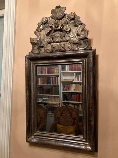 Miroir à fronton en bois mouluré et sculpté d'une corbeille de fleurs et lambreq