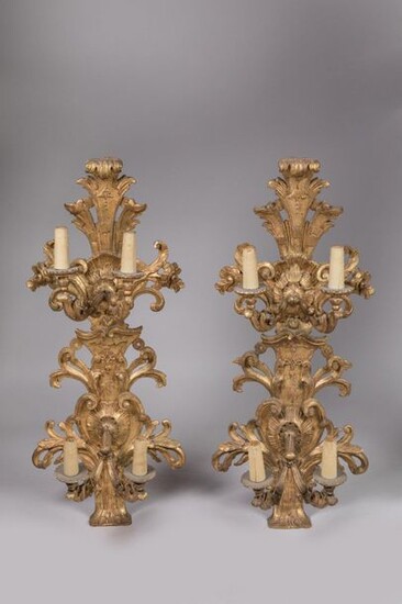 Pair of large SPLACES in carved and gilded wood, with four light arms on two registers in the shape of acanthus bases. Baroque openwork decoration of natural leaves, acanthus scrolls, palmettes, acanthus florets, shells and geometric motifs. Italian...