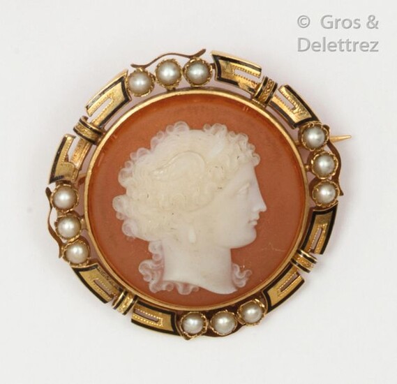 Round" brooch in enamelled yellow gold, decorated with an agate cameo representing the profile of a woman in a circle of half pearls. Diameter : 3,7cm. Gross weight : 13g.