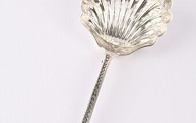 Silver sprinkling spoon, the handle underlined by a fall of asparagus tips is finished with an acanthus leaf, the spoon simulating a shell pierced with stylised plant motifs.