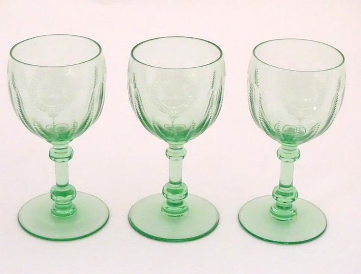 Three green glass pedestal wine glasses with engraved