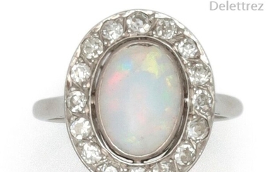 Platinum ring set with an opal cabochon in a ring of old cut diamonds. Art Deco work. Tour of doigt : 55. P. Brut : 4,6 g. (accident)