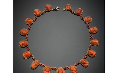 Yellow gold necklace made up of seventeen graduated orange coral cameos spaced by coral lozenges of the same colour, g...