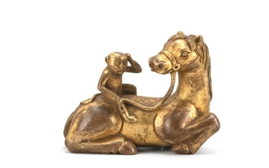 CHINESE GILT-BRONZE FIGURAL SCROLL WEIGHT In the form of a monkey resting on the back of a reclining horse. Length 3".