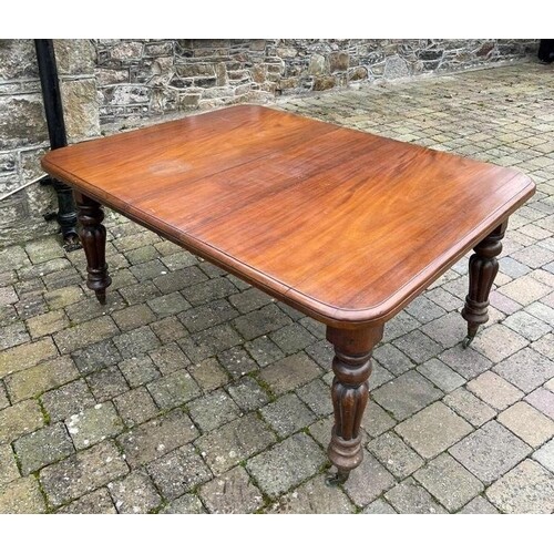 A 19TH CENTURY MAHOGANY DINING TABLE, on turned leg with cas...