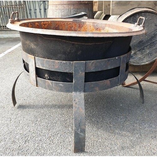 A Cast Iron Cauldron on cast iron base. Diam 87 x H 66cm.