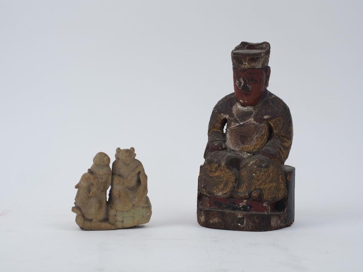 A Chinese carved and painted wood seated figure, 18th/19th Century, gilt and stamped to the body, 21cm high; together with a carved hardstone sculpture of two figures, 9cm high (2)
