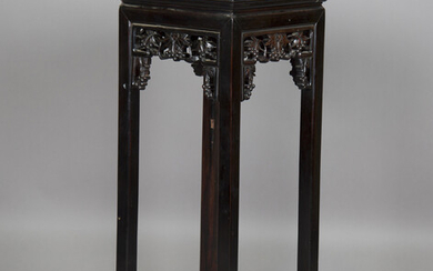 A Chinese hardwood stand, early 20th century, the square panelled top above a carved fruiting vine f