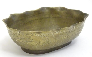 A Chinese oval brass bowl with a lobed rim, decorated