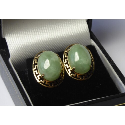 A VINTAGE PAIR OF YELLOW METAL AND JADE EARRINGS The oval ca...