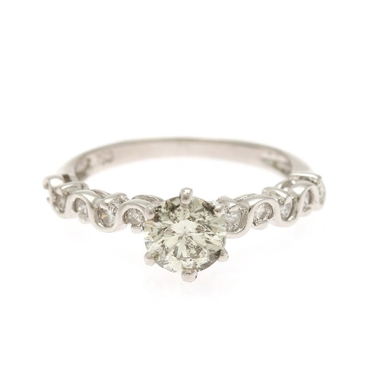 A diamond ring set with a brilliant-cut diamond flanked by ten brilliant-cut diamonds, mounted in 18k white gold. Size 51.