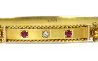 A gold diamond and ruby set oval hinged bangle