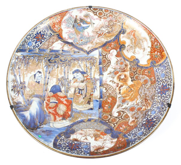 A large Japanese 19th century Imari charger decorated with three scholars in a bamboo grove