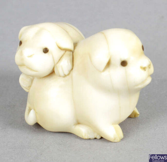 A late 19th century carved ivory netsuke modelled as two lapdogs.