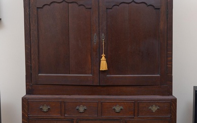 A late Georgian oak linen press on chest with two doors revealing a single shelf above four short faux drawers and five longer drawers, raised on bracket feet. height 188 x 128 x 52cm.