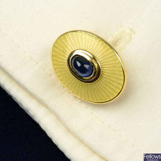 A pair of 18ct gold sapphire cabochon and yellow guilloché enamel cufflinks, with hinged reverse, by Deakin & Francis.