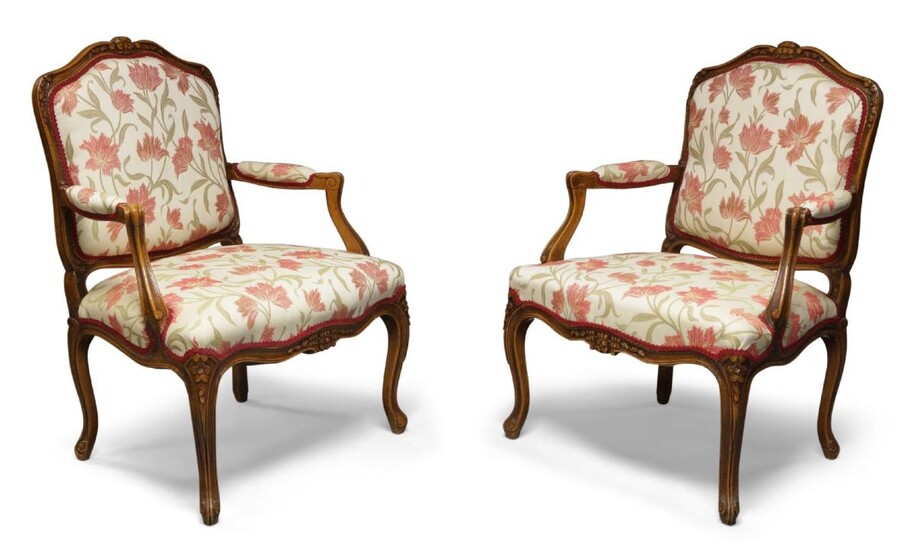 A pair of Louis XV style fruitwood armchairs, 20th century, with floral upholstered back and sprung seats, padded arm rests, scrolled arm supports, carved crest rails and seat rails, raised on cabriole legs, 98cm high, 70cm wide, 55cm deep (2)