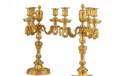 A pair of Louis XVI style gilt bronze four-light candelabra | Paire de candélabres à quatre lumières en bronze doré, de style Louis XVI