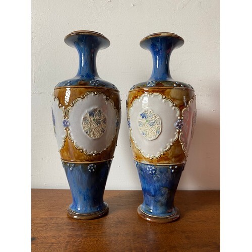 A pair of Royal Doulton vases decorated with panels of flowe...