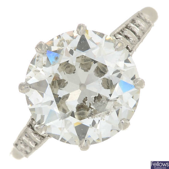 A platinum circular-cut diamond single-stone ring, with textured shoulders.