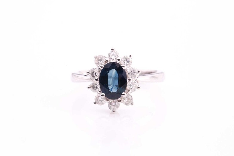 A sapphire and diamond cluster ring, set with an...