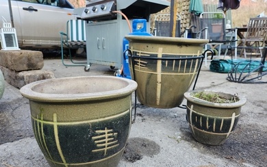 A set of three stone glazed green garden planters, the large...