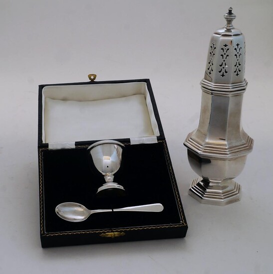 A silver sugar caster, Birmingham, 1946, Ernest W Haywood, with knopped finial above octagonal body and stepped base, 21.5cm high; together with a silver christening set comprising an egg cup and spoon, Birmingham, 1961, in fitted case, Lanson Ltd...