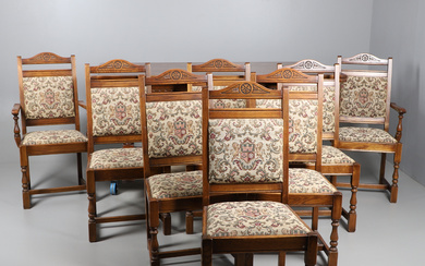 AN "OLD CHARM" CARVED OAK EXTENDING DINING TABLE AND EIGHT DINING CHAIRS.