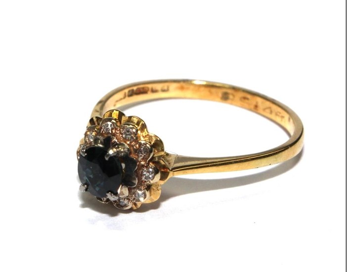 An 18 carat yellow gold ring set with diamonds and sapphires