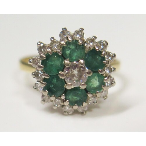 An 18ct Gold, Emerald and Diamond Cluster Ring, 4.5mm centra...