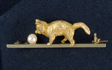 An Edwardian 9ct gold seed pearl bar brooch, designed as a kitten playing with a ball.