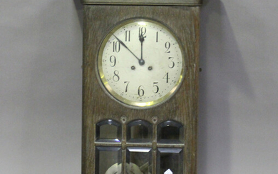 An early 20th century Arts and Crafts style oak wall clock with eight day chiming movement, height 8