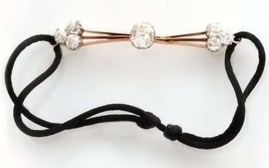 BRACELET on black cord holding a 750 thousandths yellow gold and platinum barrette with a central diamond of approximately 1 carat old cut surrounded on both sides by three old cut diamonds. Length: 5 cm. Gross weight : 4.66 gr. A black cord bracelet...