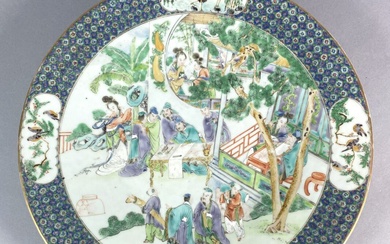 CHINE Grand plat en porcelaine émaillée polychrome à décors de scènes de palais. L'aile à...