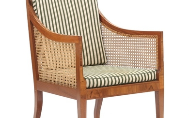 Kaare Klint: A mahogany bergére with Brazilian rosewood inlays and “shoes”. Sides, seat and back with woven cane. Cushions with green/light striped fabric.