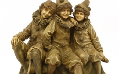 A Goldscheider figure of three children dressed as clowns